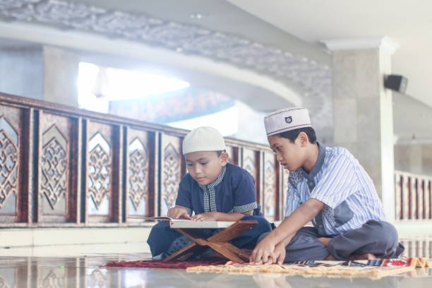 Muslim boys with his brother recite the Koran in the mosque